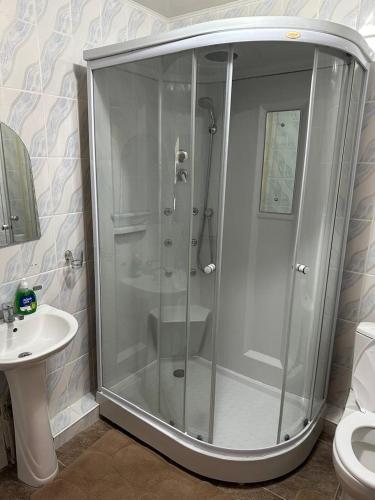 a shower stall in a bathroom with a sink at Любимый in Cholpon-Ata
