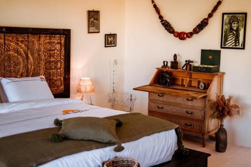 a bedroom with a large bed and a wooden dresser at Ali Baba Infinity in Essaouira