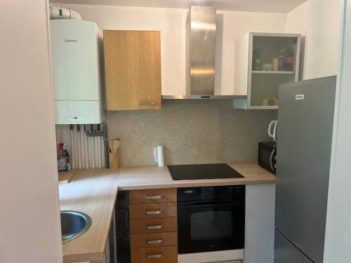 a kitchen with white cabinets and a black microwave at Maison de ville arborée avec cachet in Nanterre