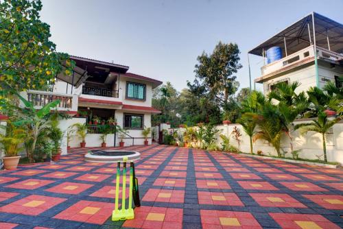 a house with a table in the middle of a courtyard at Hotel Snehaprabha - Near to Nagaon Beach Alibaug in Alibaug