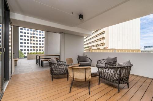 a balcony with chairs and tables on a building at Park Avenue Apt in the Heart of the City - Hosted by CanStay in Canberra