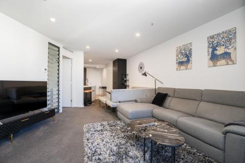 a living room with a couch and a tv at Park Avenue Apt in the Heart of the City - Hosted by CanStay in Canberra