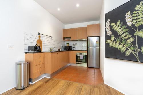 金斯顿Modern 1BR Apt 2 mins to Kingston Foreshore - Hosted by CanStay的配有木质橱柜和不锈钢冰箱的厨房