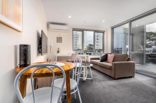 a living room with a couch and a table and chairs at 2BR Apt in the heart of the Gungahlin Town Centre - Hosted by CanStay in Harrison