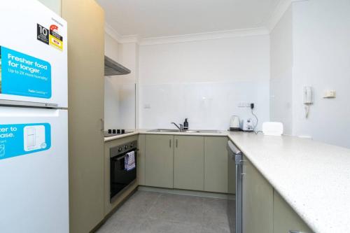 a white kitchen with a counter and a sink at 2BR Apartment Close to Glebe Park and Canberra City - Hosted by CanStay in Canberra