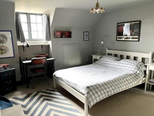 a bedroom with a white bed and a desk and a table at Village Family home in Midhurst
