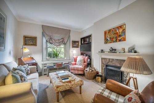 a living room with a couch and a fireplace at Village Family home in Midhurst