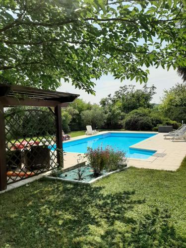- une piscine dans une cour avec un kiosque dans l'établissement la galandière, à Mensignac