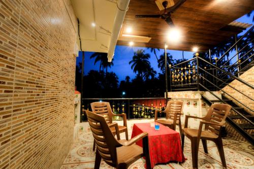 a room with a table and chairs and a balcony at Hotel Snehaprabha - Near to Nagaon Beach Alibaug in Alibaug