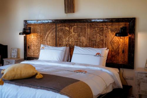 a bedroom with a large bed with a large wooden headboard at Ali Baba Infinity in Essaouira