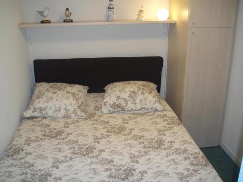 a bed with two pillows on top of it at Residence Front De Mer in Quiberon