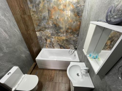 a bathroom with a toilet and a tub and a sink at Terrace View in Batumi