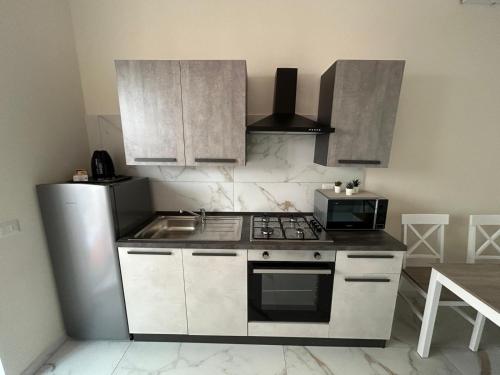 a kitchen with a stove and a microwave at B&B leperle in Torre del Greco