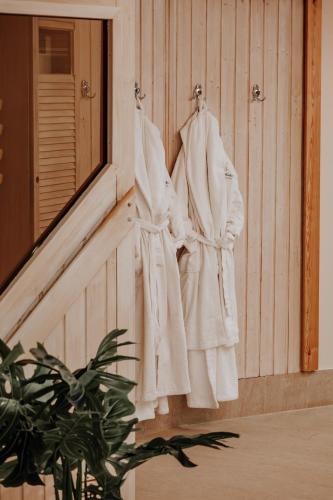 a group of white robes hanging on a wall at Arkona Strandhotel in Binz