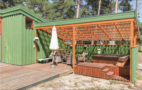 a green shed with a table and an umbrella at Holiday Home Nexø 14 in Vester Sømarken