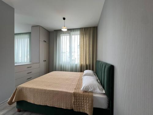 a bedroom with a bed with a green headboard at Terrace View in Batumi