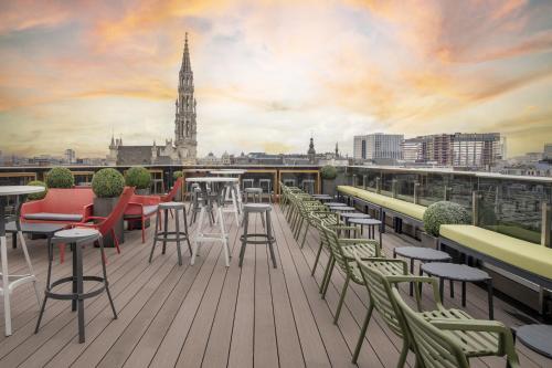 a balcony with tables and chairs and a view of a city at Warwick Grand-Place Brussels in Brussels