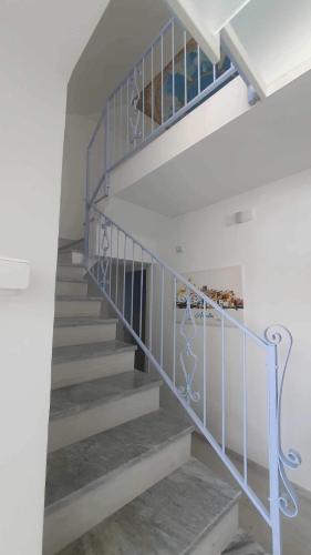 a spiral staircase with a blue railing in a house at Casa Vacanze Aurelia in Procida