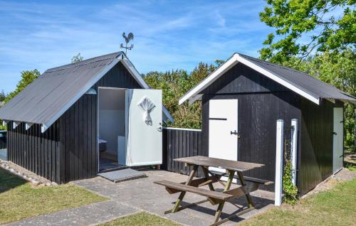 a black shed with a picnic table and a bench at 3 Bedroom Amazing Home In Kalundborg in Kalundborg