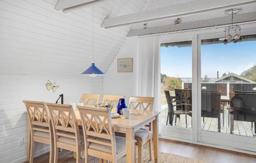 a dining room with a table and chairs and a balcony at 3 Bedroom Amazing Home In Kalundborg in Kalundborg