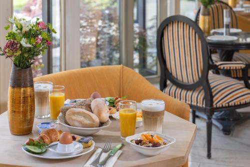 a table with a plate of food and glasses of orange juice at Dreams Beckum in Beckum