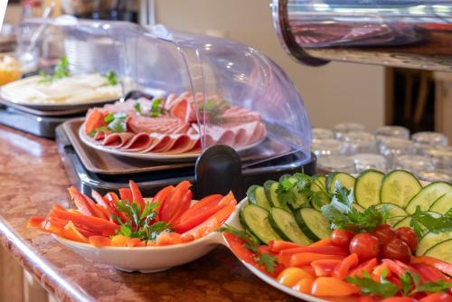 a buffet with plates of meat and vegetables on a counter at Dreams Beckum in Beckum
