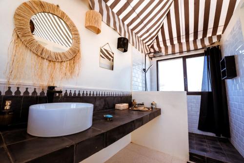 a bathroom with a large tub and a mirror at Ali Baba Infinity in Essaouira