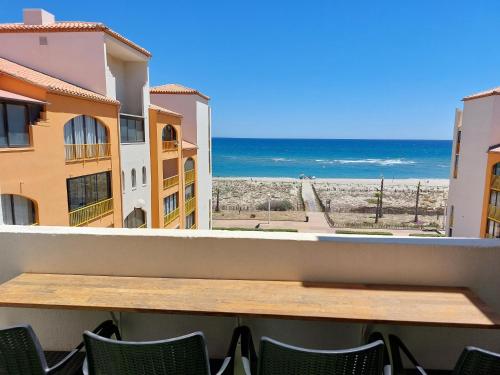 a table on a balcony with a view of the beach at Superbe vue mer avec accès direct plage et parking in Le Barcarès