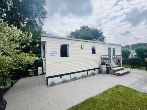 a white tiny house sitting on a patio at KD 814 - Vakantiepark Kijkduin in Kraaijenstein