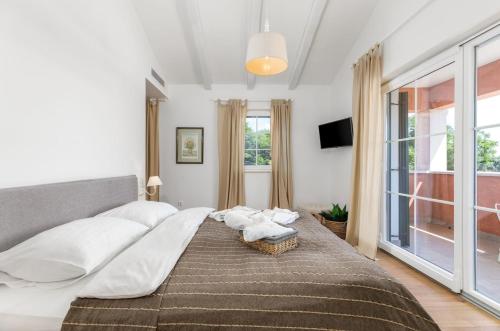 a bedroom with a large bed with white pillows at Villa Village in Tinjan