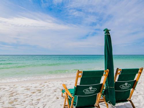 two lawn chairs and an umbrella on the beach at The Pearl of Navarre #1403 in Navarre