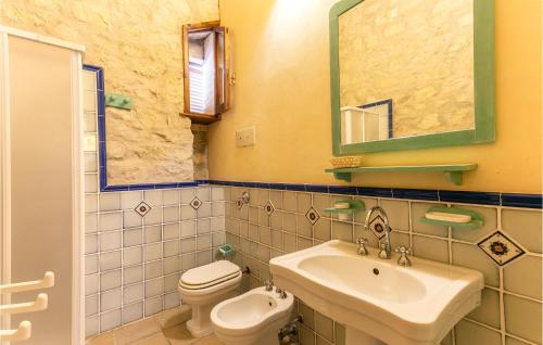 a bathroom with a sink and a toilet and a mirror at Cozy Home In Ragusa With Kitchen in Camemi