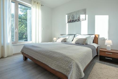 a white bedroom with a large bed and windows at Luxury White Sails Villas with a Multi Sport Court #2026# and Sea View in Pinezici