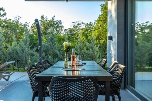 a table and chairs on a patio with a view at Luxury White Sails Villas with a Multi Sport Court #2026# and Sea View in Pinezici