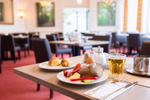 a table with two plates of food and drinks on it at Hotel Bremer Haus in Bremen