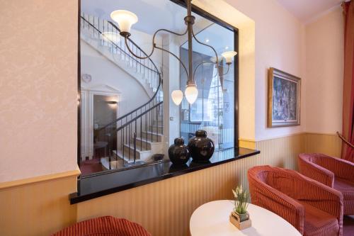 a dining room with a mirror and red chairs at Hotel Bremer Haus in Bremen