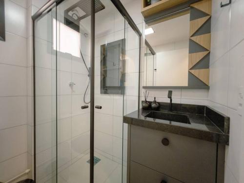 a bathroom with a glass shower and a sink at Apto Lindo prox Hospital Paraná AZ104 in Maringá