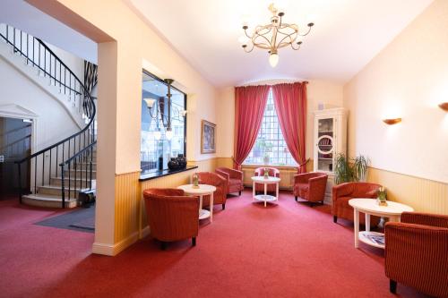 a waiting room with chairs and tables and a window at Hotel Bremer Haus in Bremen
