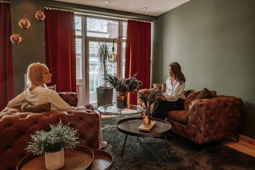 two women sitting on couches in a living room at Arkona Strandhotel in Binz