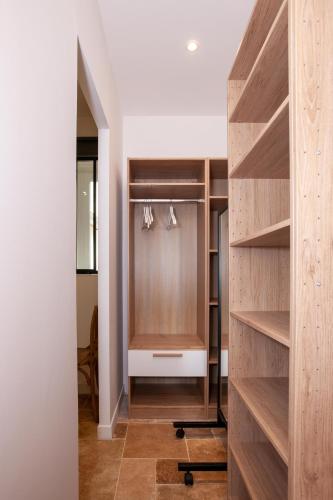- un dressing avec des étagères et des cintres en bois dans l'établissement Les Tropeziennes de Libourne, à Libourne