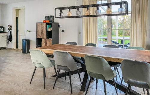 a dining room with a large wooden table and chairs at Horsterhoek in Zeewolde