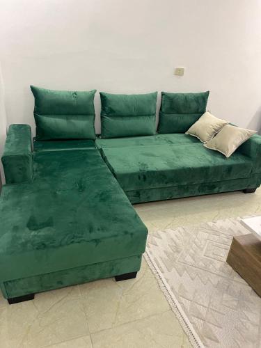 a green couch sitting in a living room at Uptown urban apartment in Jerash