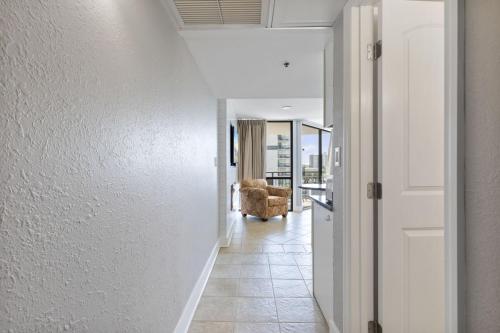 a hallway leading to a living room with white walls at Spectacular Oceanview Condos in Myrtle Beach