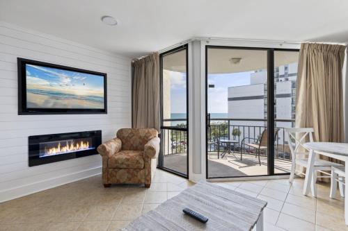 a living room with a chair and a fireplace at Spectacular Oceanview Condos in Myrtle Beach
