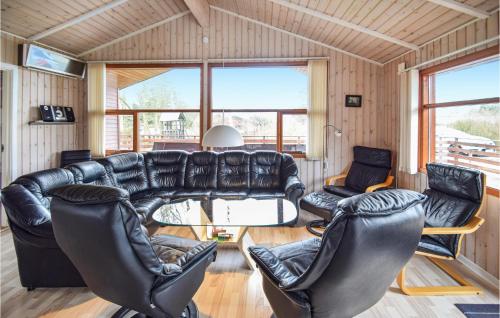 a living room with a leather couch and chairs at Holiday Home Bellisvej Tranekær Ix in Skattebølle