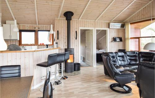 a living room with leather chairs and a kitchen at Holiday Home Bellisvej Tranekær Ix in Skattebølle