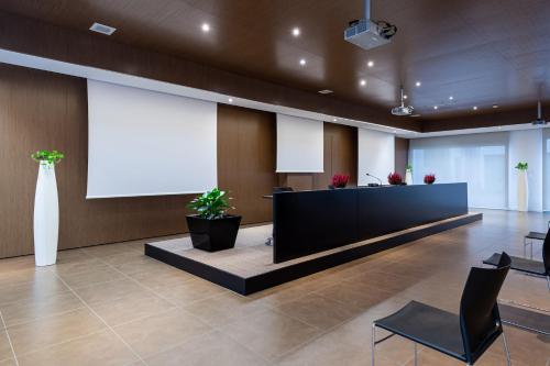 a waiting room with a large screen in a building at UNA HOTELS Le Terrazze Treviso Hotel & Residence in Villorba