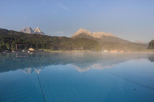 a large body of water with mountains in the background at Loewe Dolomites in San Candido