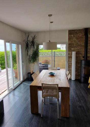 une salle à manger avec une table et des chaises en bois dans l'établissement maison plain pied, à Pouldreuzic