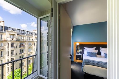 a bedroom with a bed and a large window at Hôtel Le Cercle Tour Eiffel in Paris